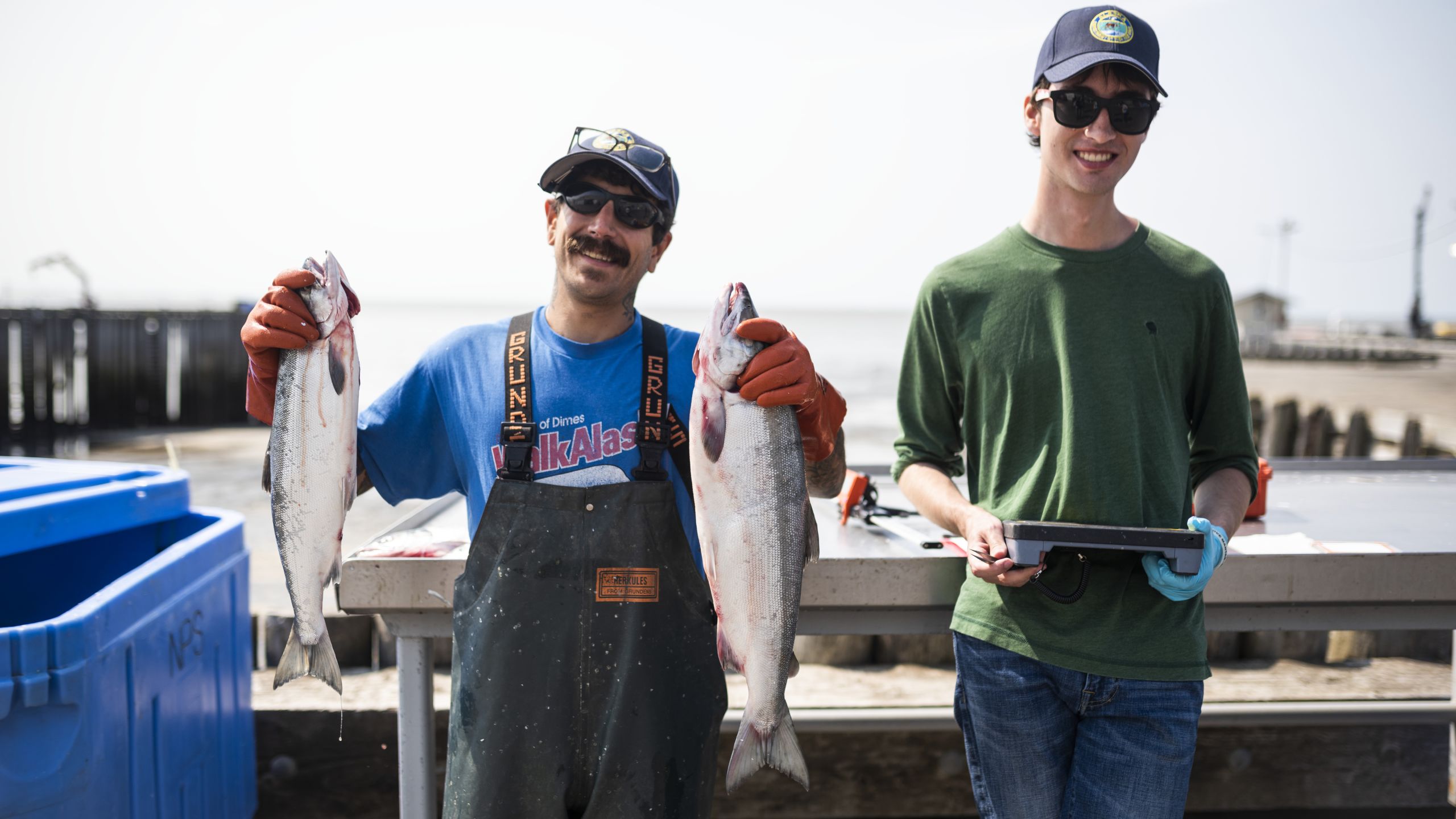 A fisherman holding two salmon